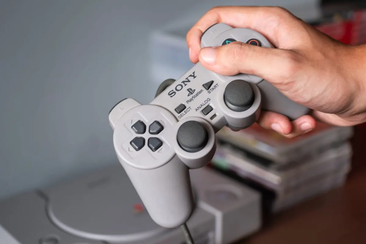 A PlayStation controller next to a stack of games